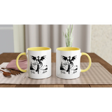 Two fantasy-themed white ceramic mugs with yellow handles, perfect for coffee or hot beverages on a table.
