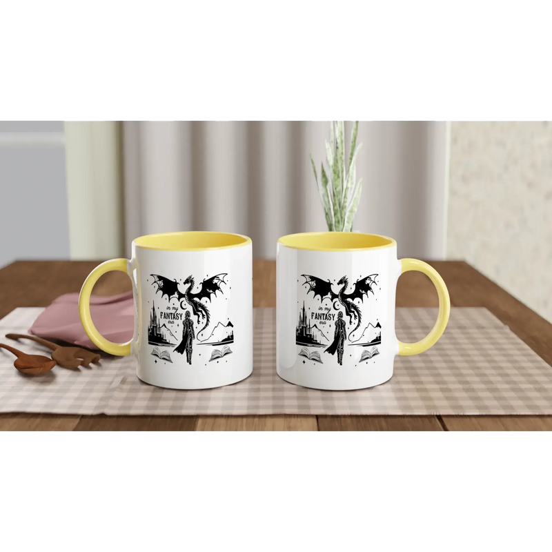 Two fantasy-themed white ceramic mugs with yellow handles, perfect for coffee or hot beverages on a table.